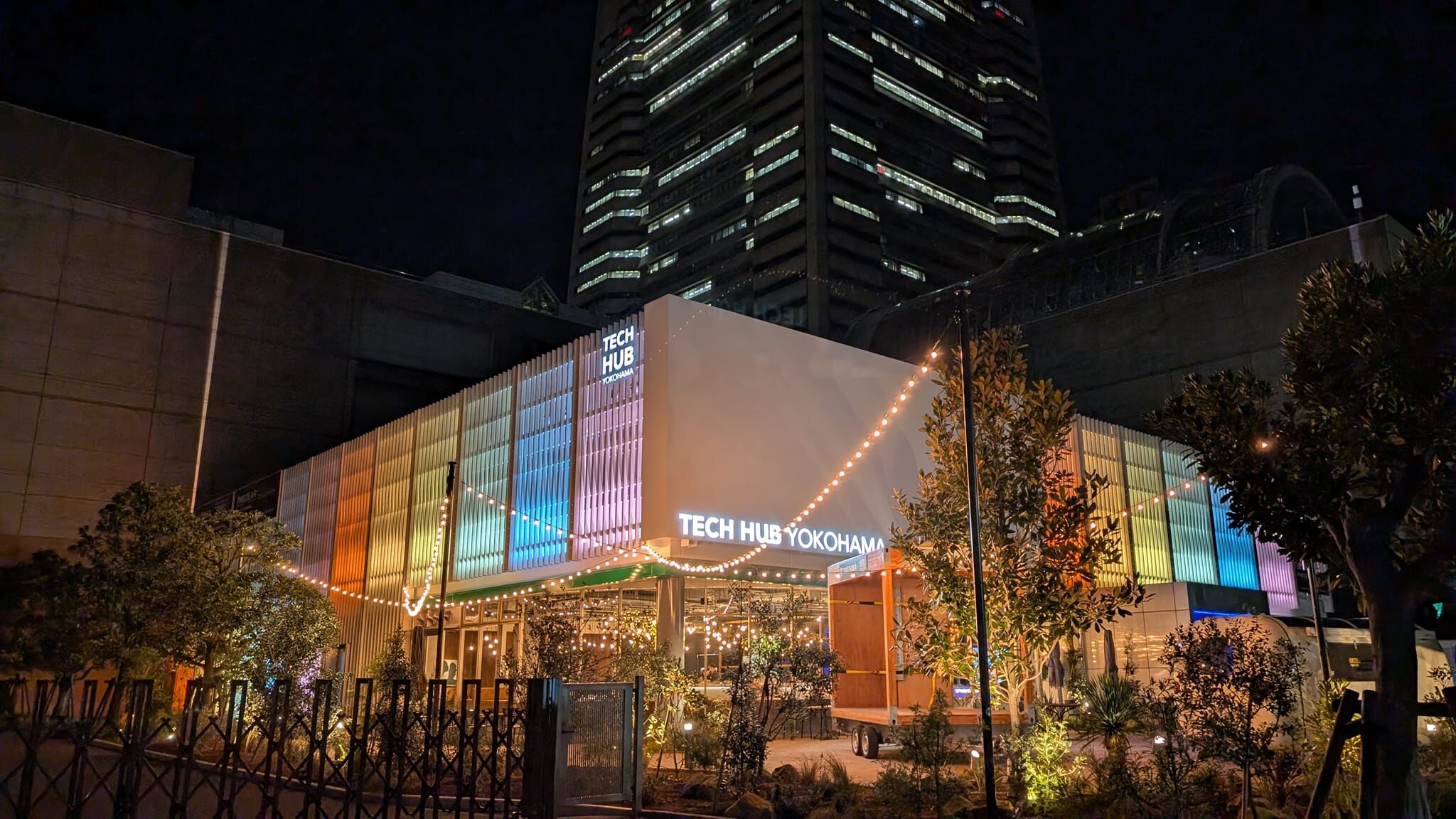 Outside view of colorfully lit building with Tech Hub Yokohama on side