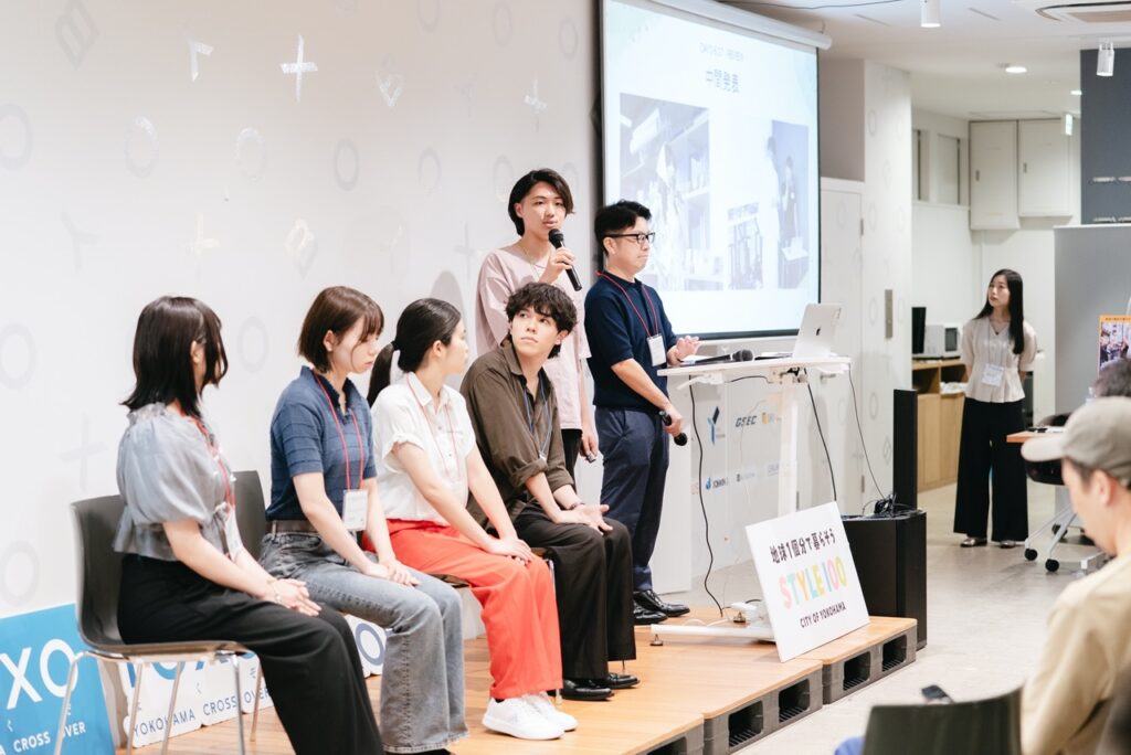 20250711_87-大-1024x684 people standing and speaking in front of a room